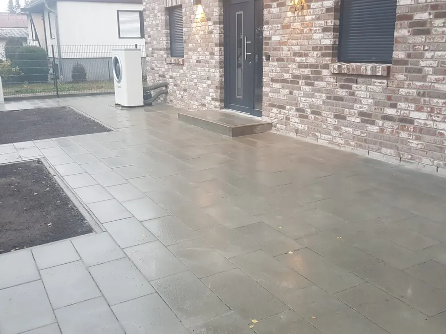 Große gepflasterte Hoffläche mit Stellplätzen an einem Wohnhaus